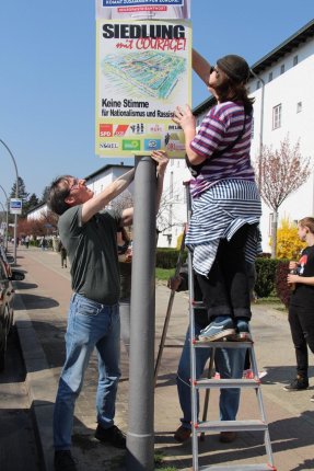 Ein Plakat wird aufgehängt