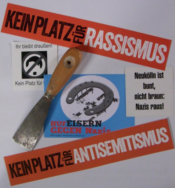Bild mit Spachtel und Hilfsmittel zum Überkleben rechter Parolen